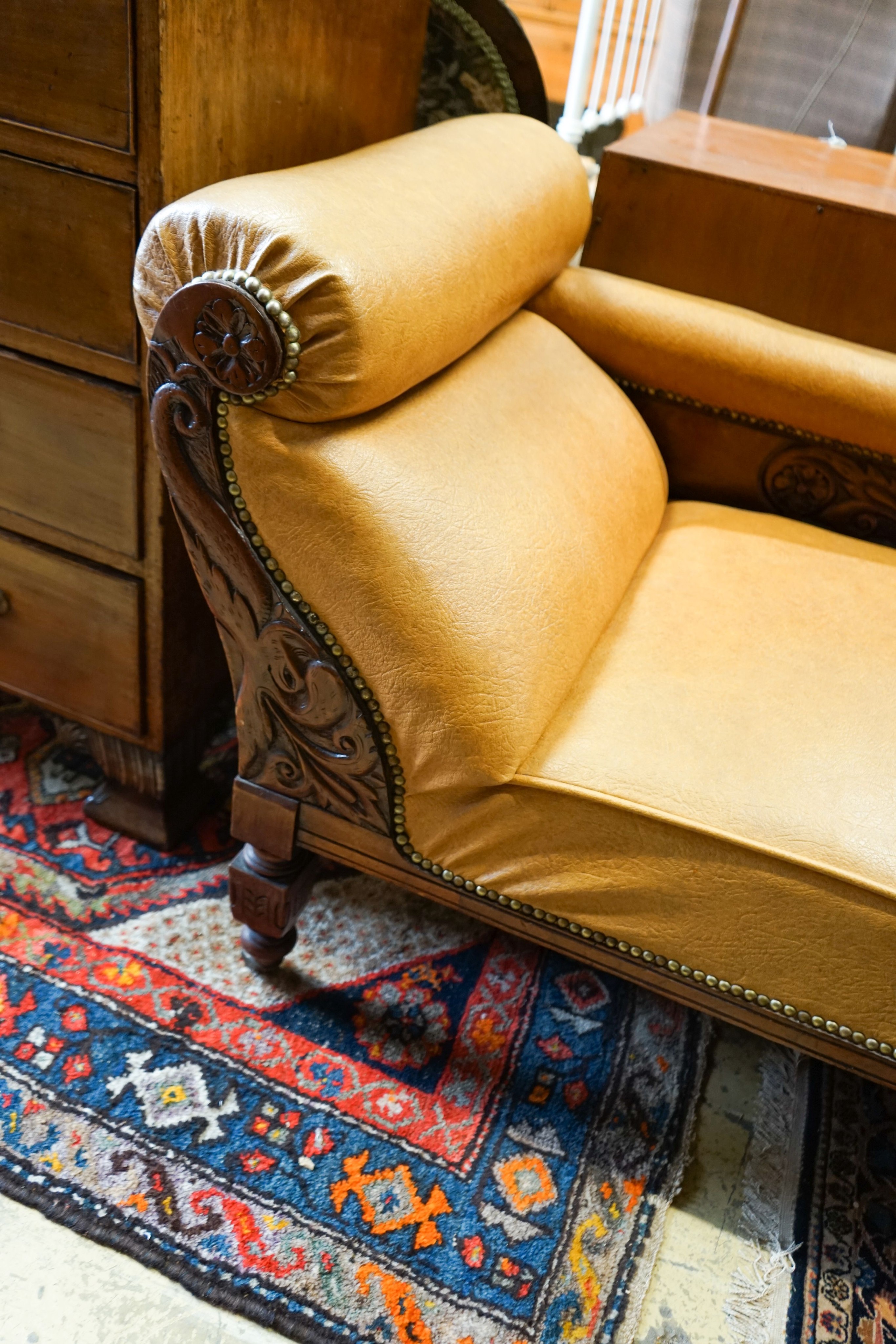 A late Victorian carved mahogany chaise longue with rexine upholstery, length 175cm, depth 60cm, height 74cm